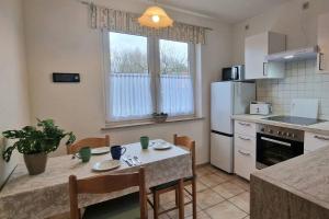 a kitchen with a table with chairs and a refrigerator at Apartment Kleine Auszeit in Wiendorf