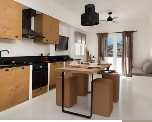 a kitchen with a wooden island in a room at Batsi view house in Andros