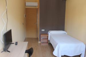 a hospital room with two beds and a television at Hostal Cal Siles in El Prat de Llobregat