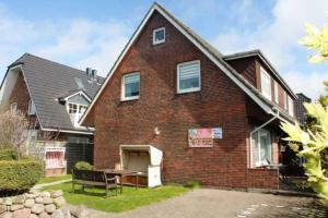 a brick house with a table in the yard at Sylt Ferienwohnung 1 Westerland in Westerland