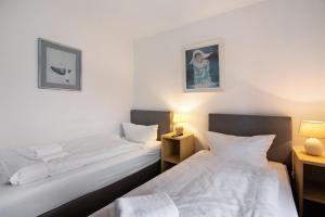 two twin beds in a room with two lamps at Sylt Ferienwohnung 1 Westerland in Westerland