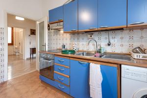 a kitchen with blue cabinets and a sink at Depandance Resort in Borgo San Lorenzo