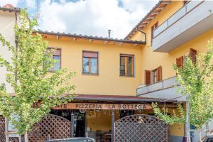 a yellow building with a sign for a pizza la tortrice at Depandance Resort in Borgo San Lorenzo