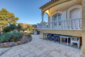 a patio with chairs and a balcony on a house at Madrague St Vincent Apt B in Le Grau-dʼAgde
