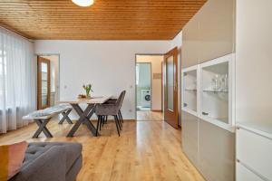 a living room and dining room with a wooden ceiling at Ferienwohnung am Bächler in Hagnau