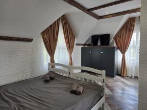 a bedroom with a bed with a tv and windows at White House Apart Hotel in Bălţi