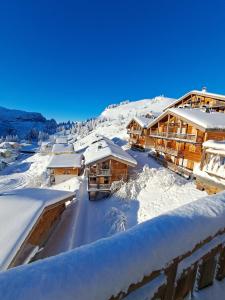 a winter view of a resort with snow covered roofs at Superbe Duplex- Résidence Alpine in Arâches-la-Frasse