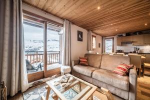 a living room with a couch and a large window at Superbe Duplex- Résidence Alpine in Arâches-la-Frasse