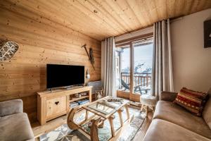 a living room with a couch and a television at Superbe Duplex- Résidence Alpine in Arâches-la-Frasse
