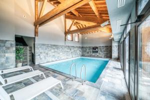 a swimming pool in a house with wooden ceilings at Superbe Duplex- Résidence Alpine in Arâches-la-Frasse