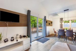 a living room with a television and a table with chairs at Ferienhaus 14 in Bad Arolsen