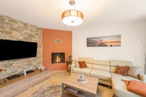 a living room with a couch and a tv at Domizil Eden - Erdgeschoss in Göhren-Lebbin