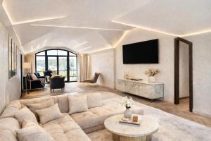 a living room with a couch and a tv at GRAND APARTMENT BALTEZERS in Riga