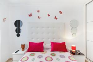 a white bedroom with a bed with pink pillows at Alohe Puertorico View in Puerto Rico de Gran Canaria +17 photos
