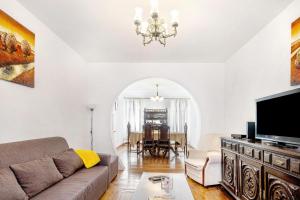 a living room with a couch and a tv at Casa Dona Isaura in Ponta Delgada