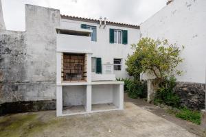 a white building with a bird cage in front of it at Casa Dona Isaura in Ponta Delgada