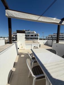 a balcony with a table and chairs on a roof at Santa Rosalia Lake & Life resort in Torre-Pacheco
