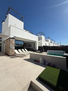 a white house with a pool and some chairs at Santa Rosalia Lake & Life resort in Torre-Pacheco