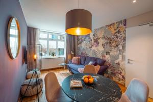 a living room with a table and a blue couch at Alte Konditorei in Lindau +38 photos