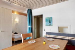 a dining room with a wooden table and a bed at Fewo Berggipfel am Feldberg in Feldberg