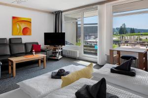 a living room with a couch and a tv at Fewo Berggipfel am Feldberg in Feldberg
