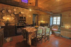 a kitchen with a table and chairs in a room at Casa De Vilar do Dão in Penalva do Castelo
