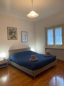 a bedroom with a blue bed with two towels on it at Casa Nova in Porte di Rendena