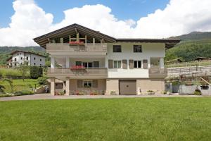 a large house with a green lawn in front of it at Casa Nova in Porte di Rendena