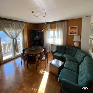 a living room with a green couch and a table at Casa Nova in Porte di Rendena