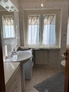 a bathroom with a sink and a toilet and windows at Casa Nova in Porte di Rendena +28 photos