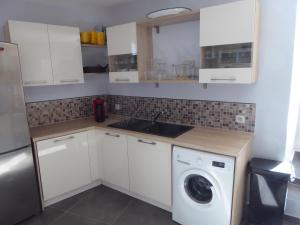 a kitchen with white cabinets and a washing machine at Maison de Village in Puimoisson +5 photos