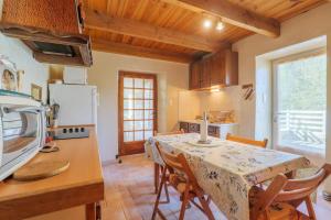 a kitchen and dining room with a table and chairs at Gite de la Troulière in Banne +13 photos