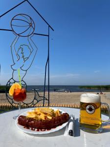 a table with a plate of food and a glass of beer at Ferienhaus Haffstille in Ueckermünde