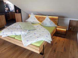 a bedroom with a wooden bed with pillows on it at Hof Sorgenfrei in Buch