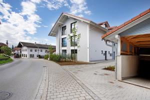 a white house on the side of a street at Design Ferienwohnung am Chiemsee in Breitbrunn am Chiemsee