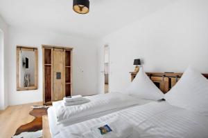 a white bedroom with two white beds in it at Design Ferienwohnung am Chiemsee in Breitbrunn am Chiemsee