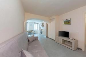 a living room with a couch and a television at Nonna Sandrina in Monferrato hills - Happy Rentals in Garbagna