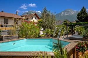a swimming pool in a garden with mountains in the background at La suite des Sommets in Barberaz