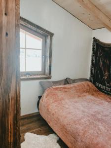 a bedroom with a large bed with a window at Ferienwohnung Katie in Hopfgarten im Brixental