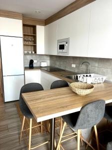 a kitchen with a wooden table and chairs at Bluebell L6 in Armeñime