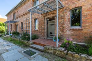 a brick building with an open door and a patio at Ferienwohnung im Pferdestall in Angermünde