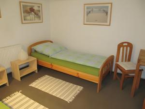 a bedroom with a bed and a chair and a table at Ferienwohnung Lortz in Cuxhaven