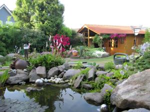 a garden with a pond with rocks and flowers at Ferienwohnung Lortz in Cuxhaven