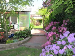 a garden with purple flowers and a walkway at Ferienwohnung Lortz in Cuxhaven +3 photos