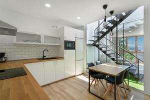 a kitchen and dining room with a spiral staircase at Los Mojones in Artenara