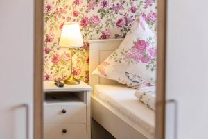 a small bedroom with pink flowers on the wall at Englisches Apartment in Kerken