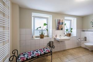 a bathroom with a sink and a toilet and two windows at Englisches Apartment in Kerken
