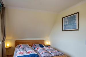 two beds in a small room with two lamps at Ferienhaus Beckerwitz in Beckerwitz