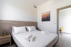 a bedroom with a large white bed with towels on it at Le scuderie 5 in Galatone +28 photos