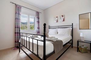 a bedroom with a bed and a window at Villa Ermina Paleros in Paleros
